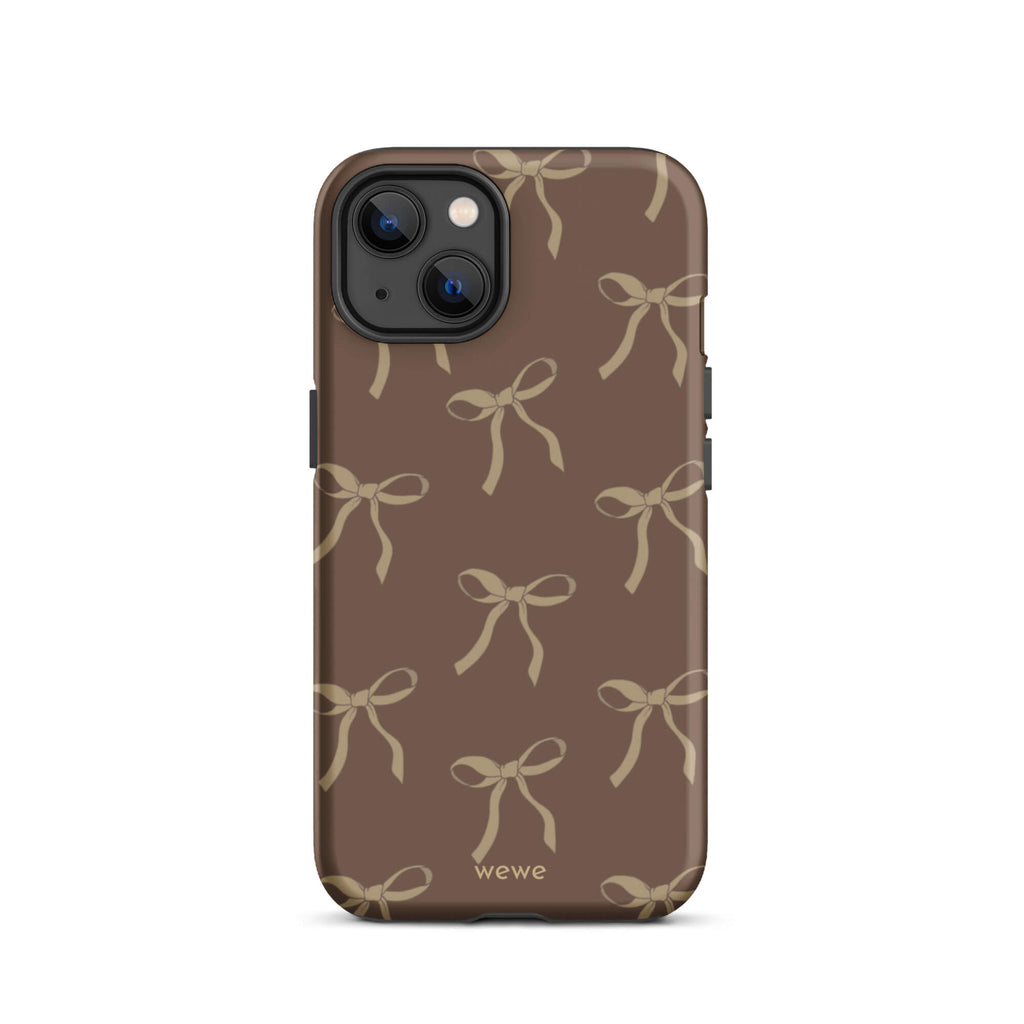 Custom iPhone 13 tough case in matte dark espresso brown featuring an all-over repeating pattern of light taupe/tan ribbons/bows, with 'wewe' branding at the bottom.