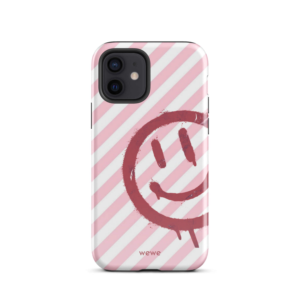 Custom iPhone case 12 with a pink and white diagonal stripe background and a red spray paint graffiti smiley face.